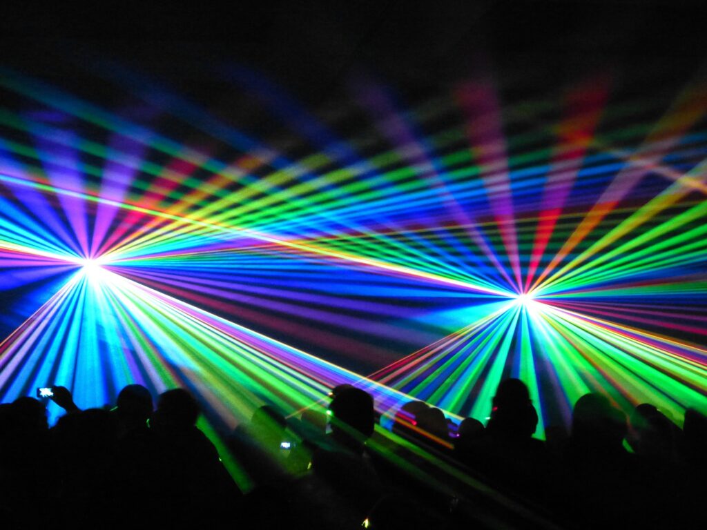 Image of a crowd with multi-colored light beams spanning across the crowd. Cold Laser Therapy offered at the Karlfeldt Center of Meridian, Idaho.
